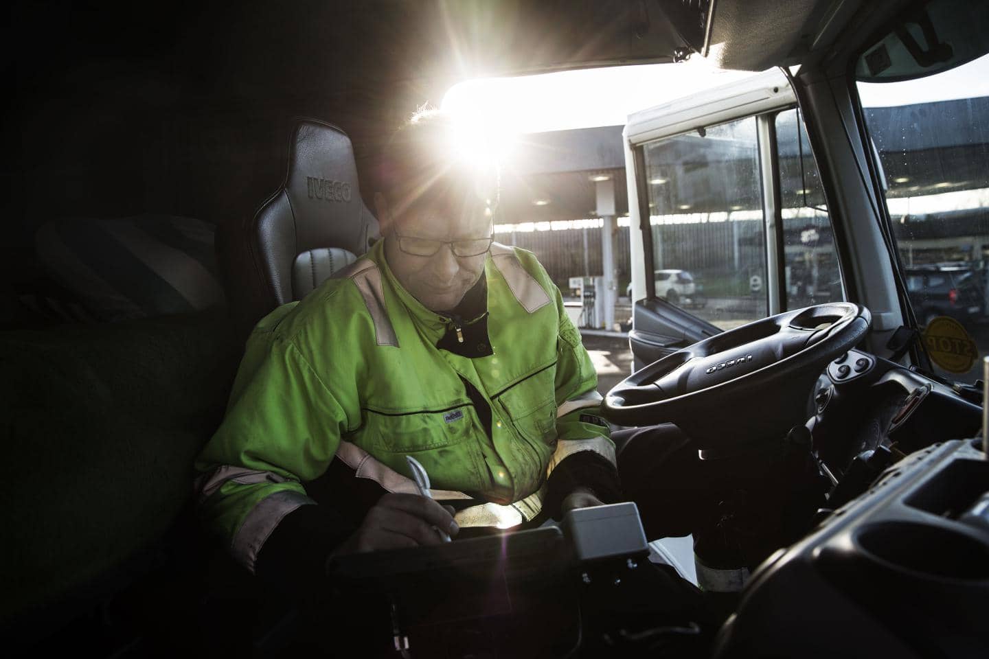 Person iført refleksjakke arbejder inde i en lastbil førerkabine