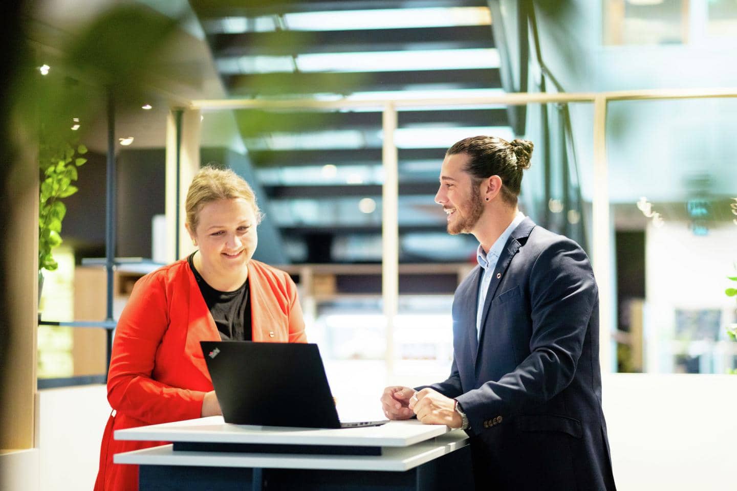 Kvinde og mand der griner ved en computer