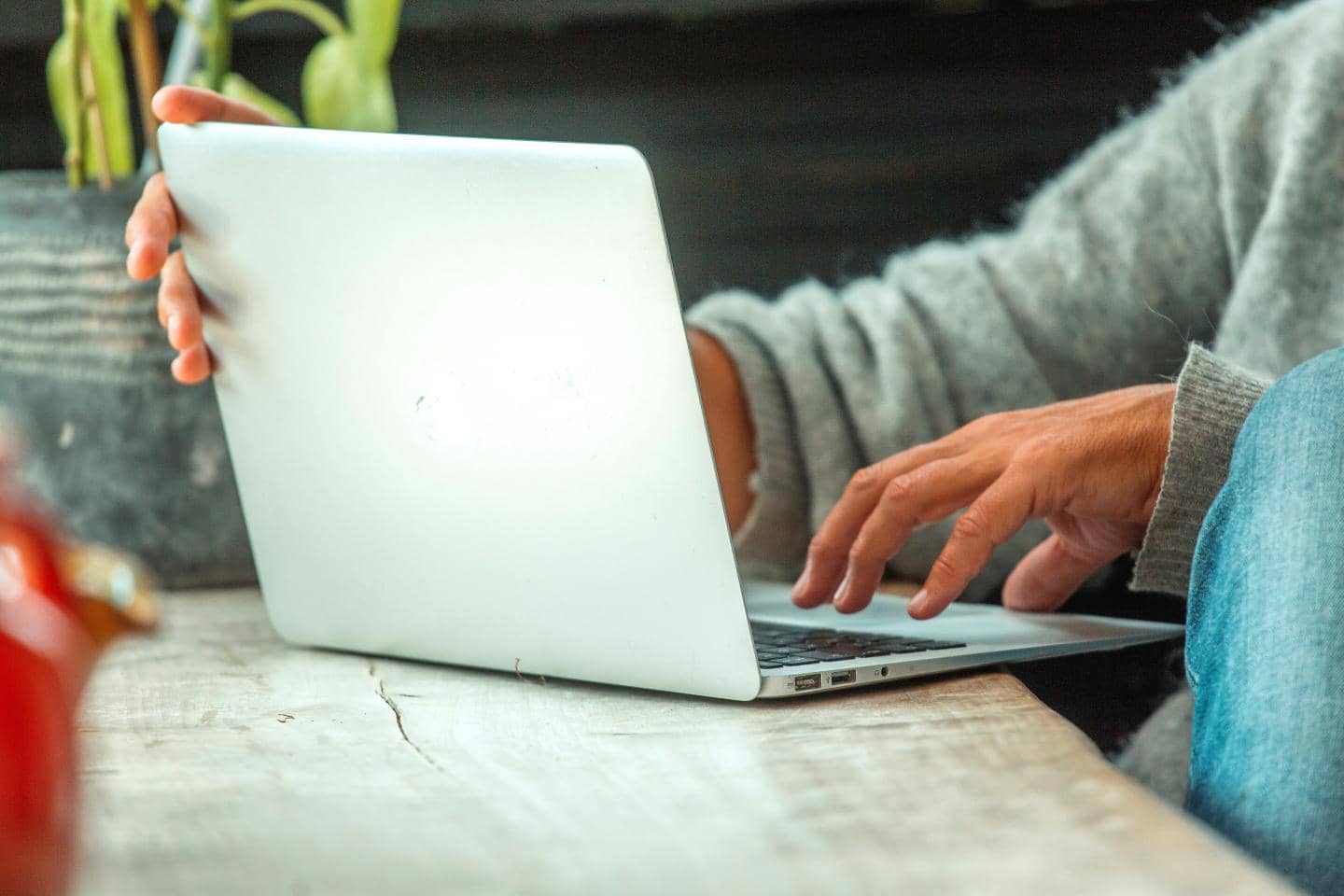 Person arbejder på en bærbar computer ved et bord